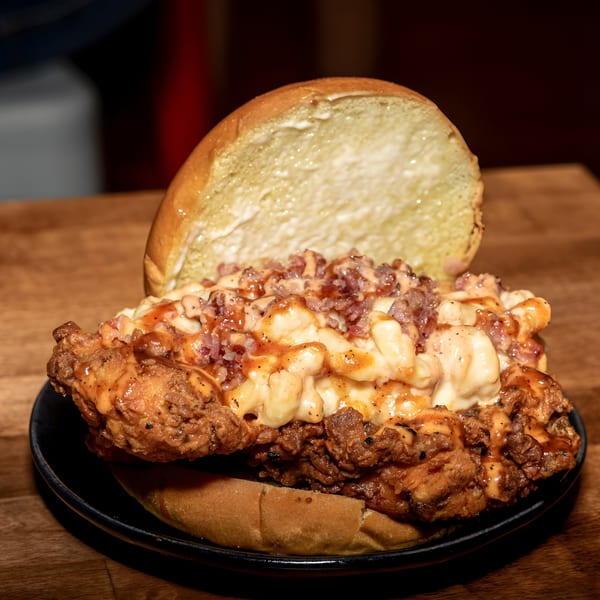 A Fire Nashville Hot Chicken sandwich with fried chicken, mac and cheese, bacon, and sauce.
